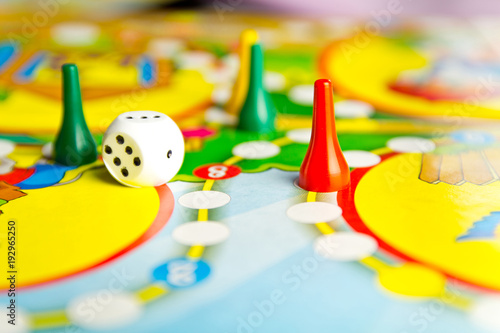 Board games for the home. Yellow, green and red plastic chips and dice on Board games for children . Selective focus