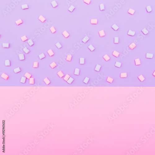 colorful marshmallow laid out on blue and pink background. pastel creative textures. minimal