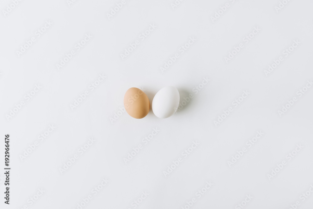 white and brown eggs laying on white background