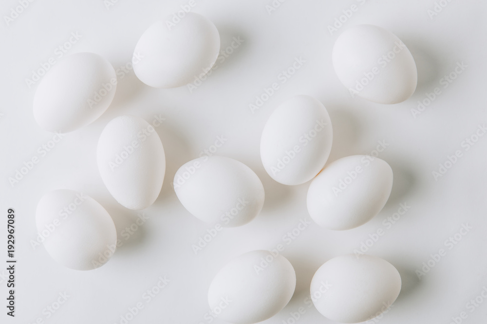 white eggs scattered on white background white eggs scattered on white background