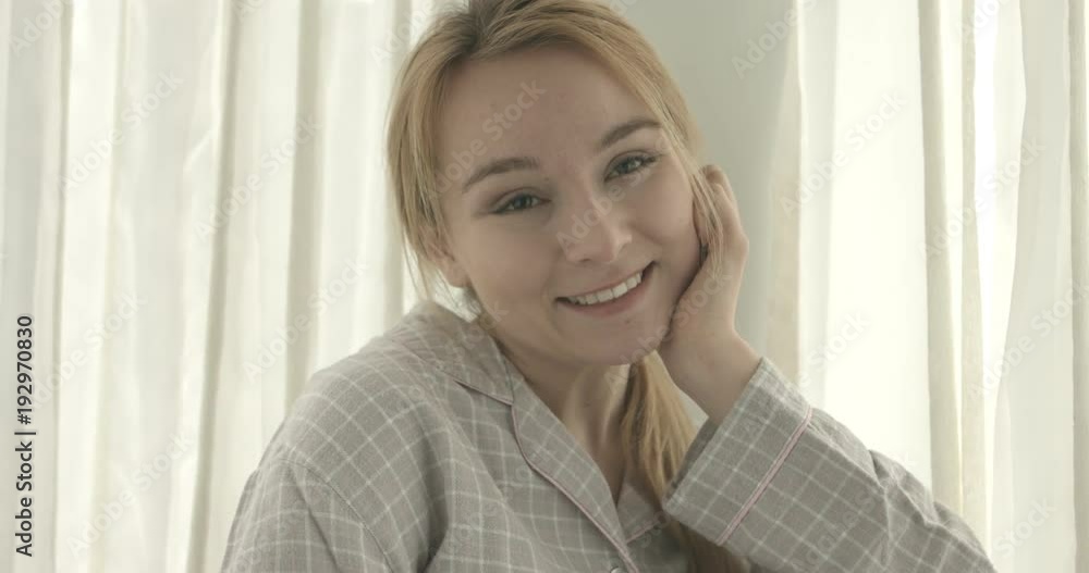 Beautiful smiling woman looking at camera at home in the living room Beautiful smiling woman looking at camera at home in the living room