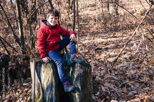 portrait of child in the forest on the background the trees in winter season