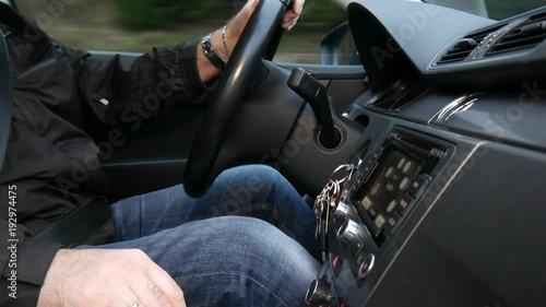 The driver drops his phone while driving. Close-up