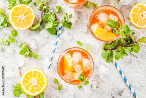 Cold summer drink. iced tea with lemon and mint, on grey stone background. Copy space top view