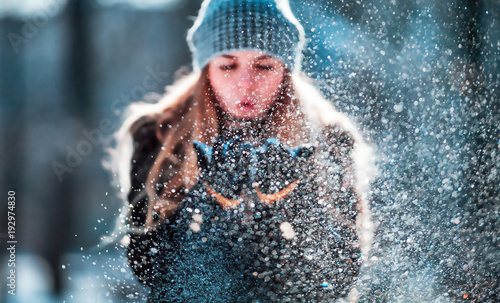 Winter woman blowing snow outdoor, flying snowflakes