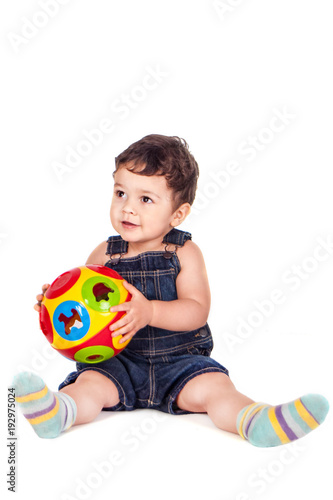 cute toddler in a denim overall with an educational toy 
on a white background
