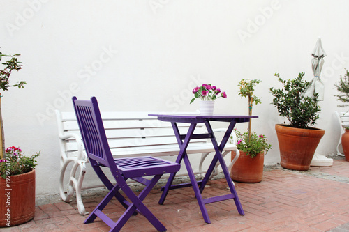 Violet wooden chairs and a table with a bouquet of flowers