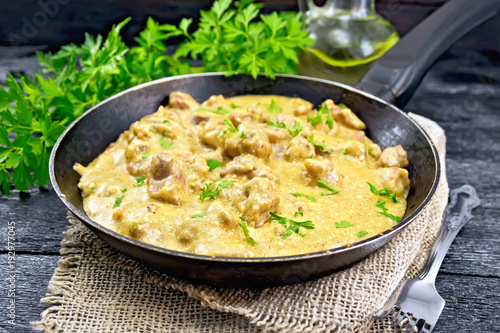 Meat stewed with cream in pan on burlap