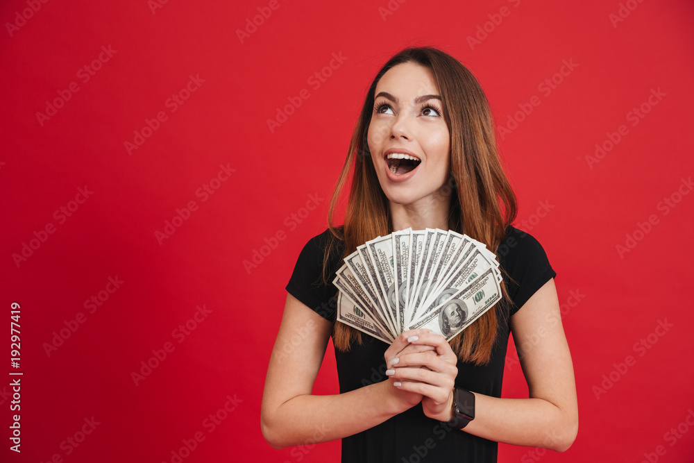 Portrait of an excited girl holding bunch of money banknotes Portrait of an excited girl holding bunch of money banknotes