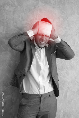 Overworked young man having headache once onerous operating day.sick man headache, dizzyness, sinus inflammation, stress, migraine.black and white body pain concept