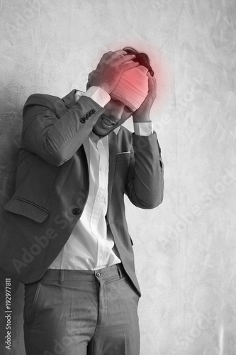 Overworked young man having headache once onerous operating day.sick man headache, dizzyness, sinus inflammation, stress, migraine.black and white body pain concept