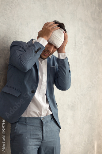 Overworked young man having headache once onerous operating day.sick man headache, dizzyness, sinus inflammation, stress, migraine.
