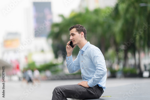 Handsome businessman speaking on the phone. © Nattanon