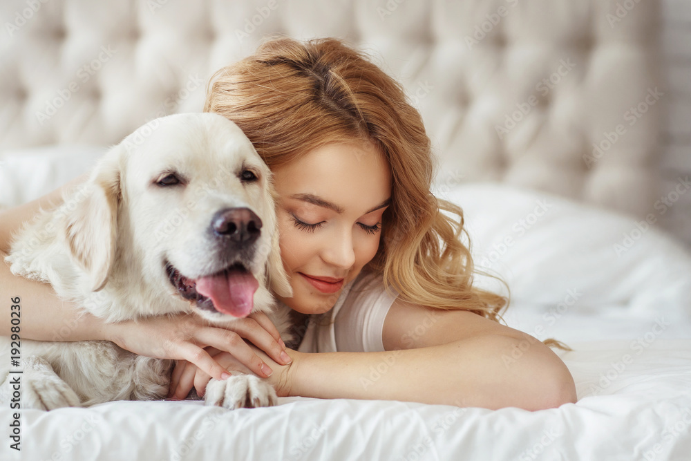 Beautiful teen girl with golden retriever dog in a bed Beautiful teen girl with golden retriever dog in a bed