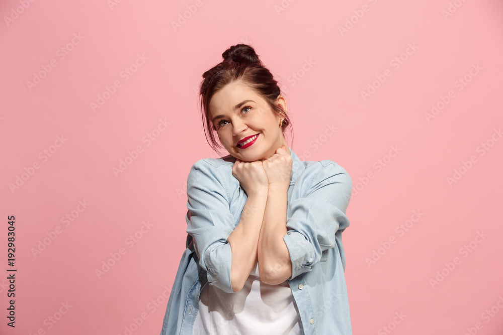 The happy business woman standing and smiling against pink background. The happy business woman standing and smiling against pink background.