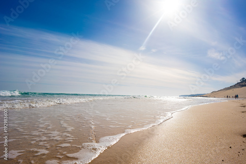 Fototapeta Naklejka Na Ścianę i Meble -  Calm sea and surf on a sandy beach. summer sea in Sunny weather with blue sky. Beautiful sandy beach and transparent waves
