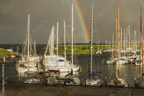 View of  Scharendijke boat harbor with a rainbow , Netherlands photo