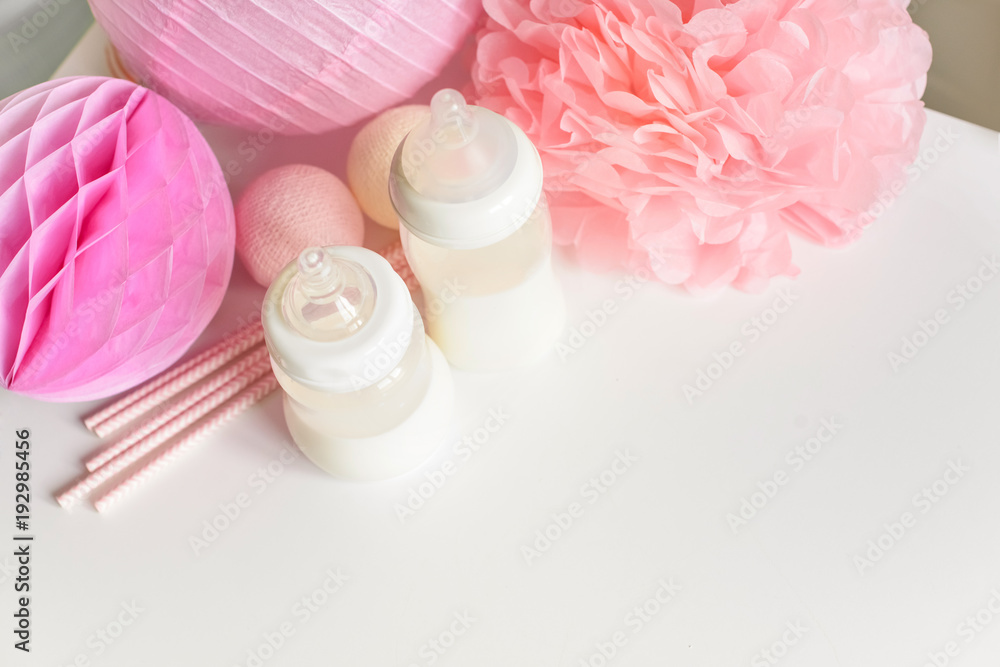 Baby bottles with breast milk with various festive paper decor. It's a girl or baby birthday celebration concept. Baby shower concept. Top view. Free copy space. Baby bottles with breast milk with various festive paper decor. It's a girl or baby birthday celebration concept. Baby shower concept. Top view. Free copy space.