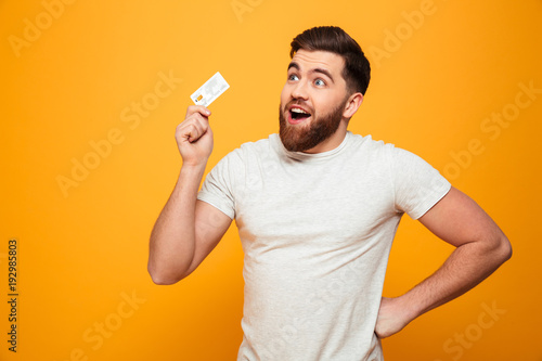 Portrait of a happy bearded man holding credit card