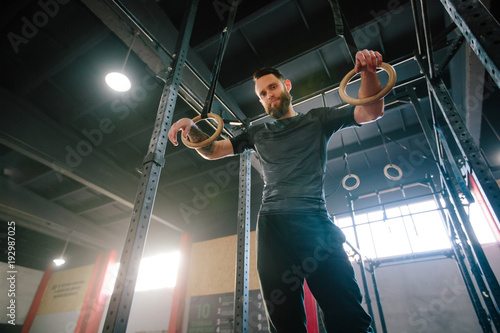 Athlete man with a beard exercising in a gym