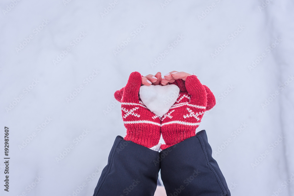 Hands holding snow heart
