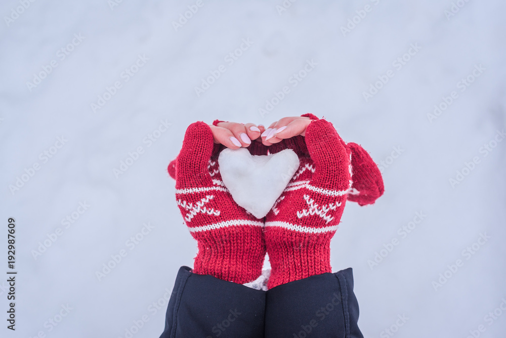 Hands holding snow heart