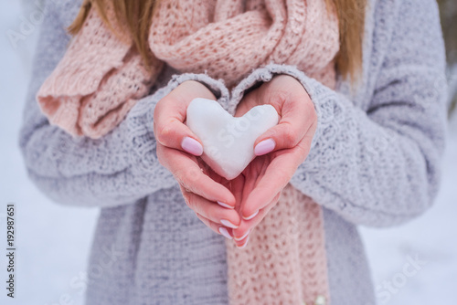 Hands holding snow heart