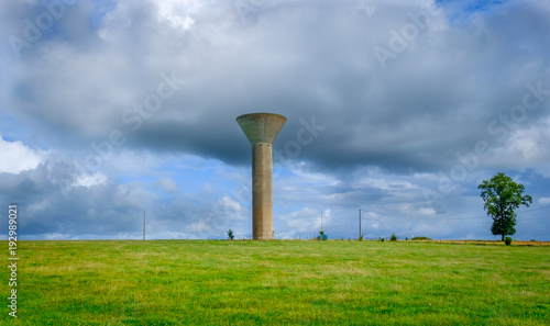 Water tower in the Mayenne countryside on an overcast day in summer, France