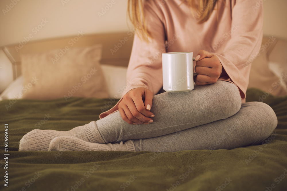 Photo of woman relaxing while reading a book and drinking coffee. Photo of woman relaxing while reading a book and drinking coffee.