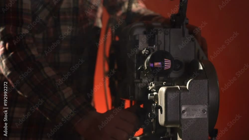 A man includes video projector a on red blackround A man includes video projector a on red blackround