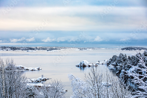 Beautiful winter day at Odderoya in Kristiansand, Norway. Trees covered in snow. The ocean and archipelago in the background. photo