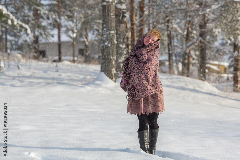 Young russian woman posing in a snowy park in winter.