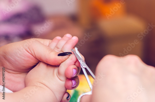 Mother cut the nails of the baby close up