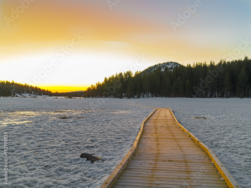 Empty Wooden footpath in an icy cold valley leading to the sunrise in the Sierra Nevada Mountains isolation concept. © gchapel