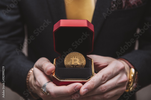 a man holds an enlarged box with bitcoin photo