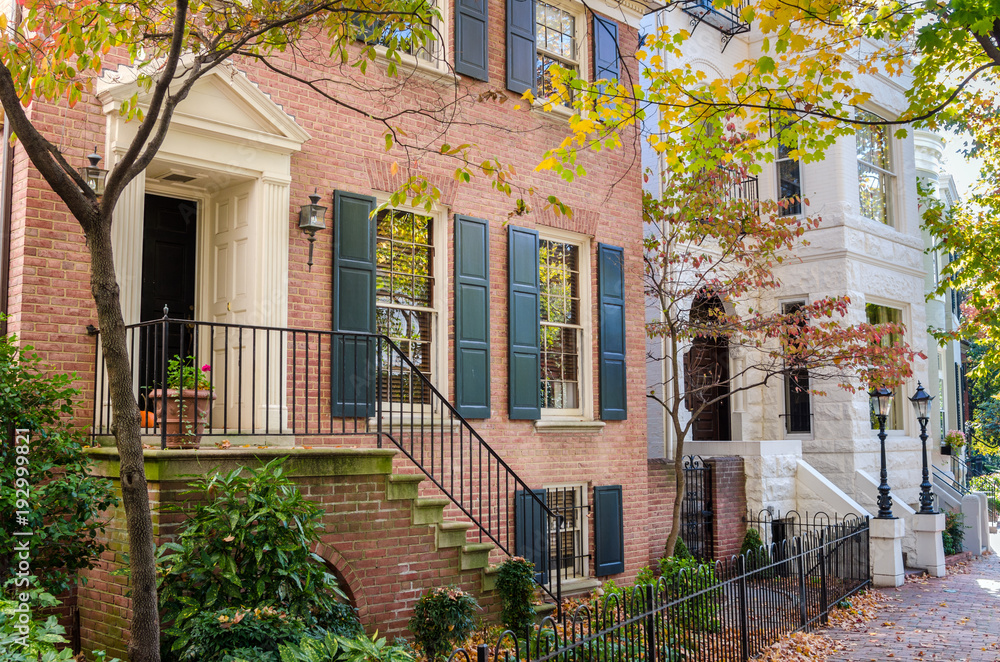 Fototapeta premium Entrance of Traditional Houses along a Brick Sidewalk on a Sunny Autumn Day