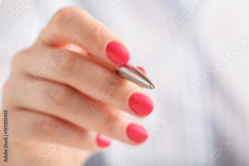 Close up female with maniqure hand hold pen