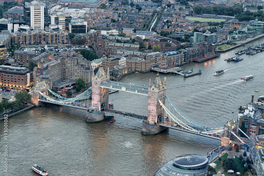 LONDON - SEPTEMBER 24, 2016: Aerial view of Tower Bridge and city skyline at night. The city attracts 30 million tourists annually