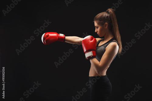 Side view of a gorgeous young woman with boxing gloves