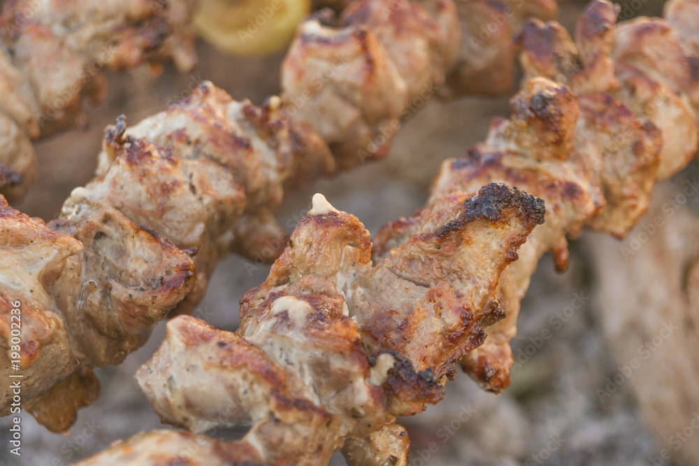 Mutton shish kebabs on skewers on the grill outdoors
