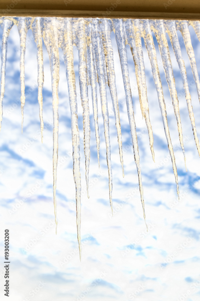 Row of Large Sparkling Icicles on Window Frame at Sky Row of Large Sparkling Icicles on Window Frame at Sky