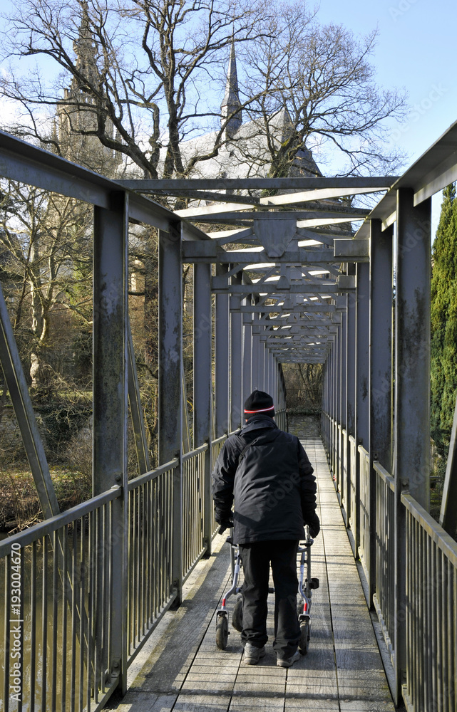 seniorin mit rollator auf einer brücke seniorin mit rollator auf einer brücke