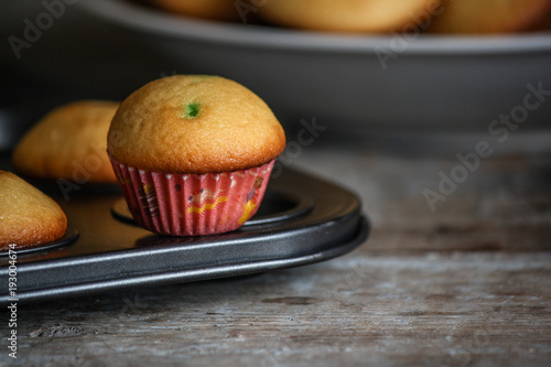 small muffins (cupcakes) - fresh pastries on a wooden surface