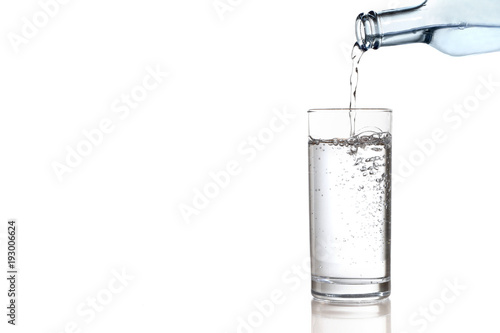 Wasser aus einer Flasche wird in ein Glas geschüttet