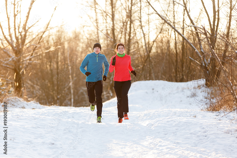 Image of running two athletes in winter park Image of running two athletes in winter park