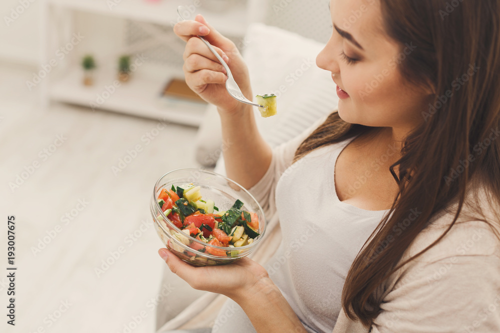 Young pregnant woman eating fresh green salad Young pregnant woman eating fresh green salad