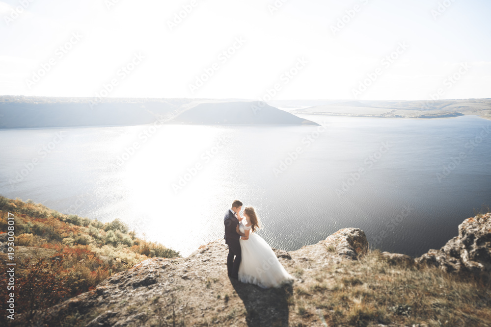 Happy and romantic scene of just married young wedding couple posing on beautiful beach