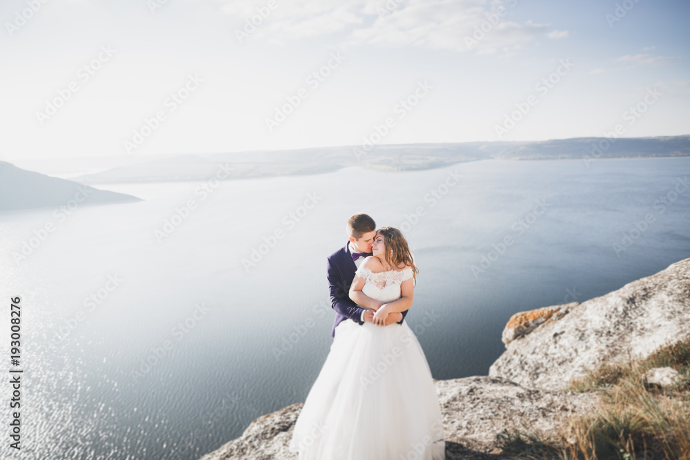 Happy and romantic scene of just married young wedding couple posing on beautiful beach Happy and romantic scene of just married young wedding couple posing on beautiful beach