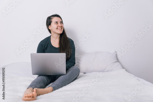 woman sit on the bed and use her laptop