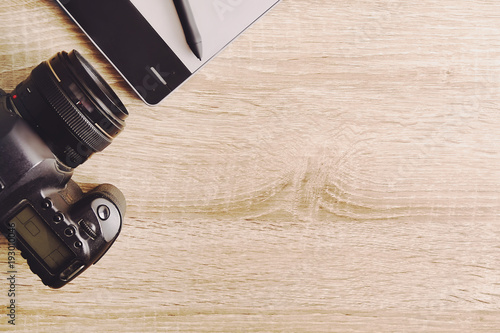 Photo blogger / photographer / it specialist's typical office space table with laptop, blank screen, coffee cup and electronics. Top view, copy space, flat lay, overhead, backdrop.